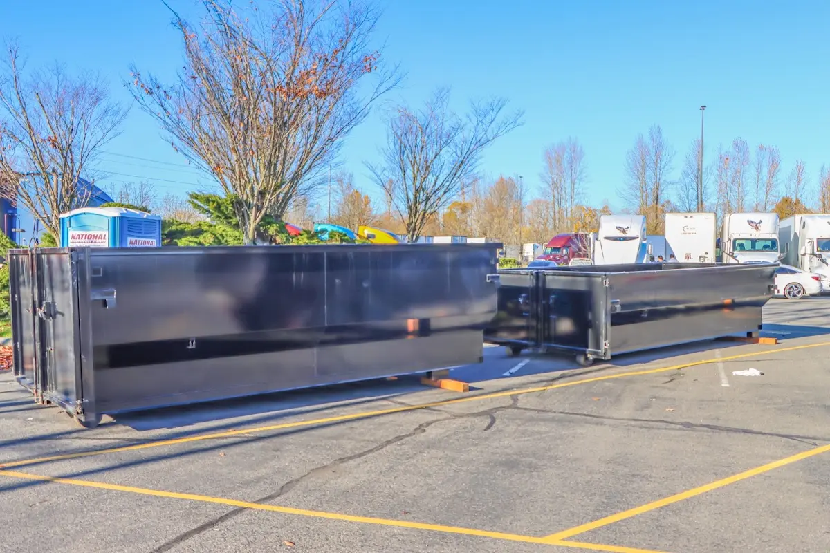 Professional dumpster rental service with roll-off container on residential driveway in Alliance